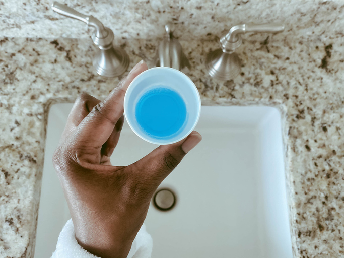 Woman Holds Cup of Mouthwash