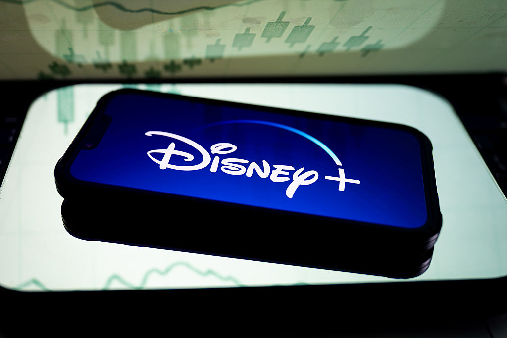In this photo illustration, a Disney+ logo seen displayed on...